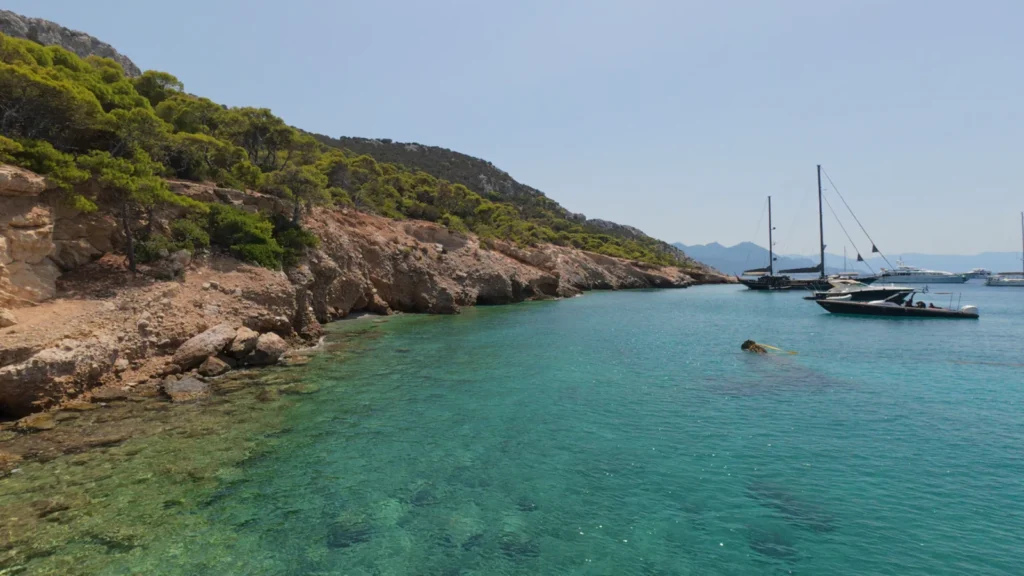 Yachts anchored in a quiet bay with clear water in the Saronic Gulf