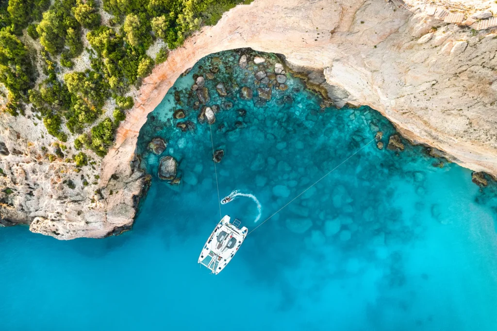 Aerial view of a catamaran in turquoise water in Greece