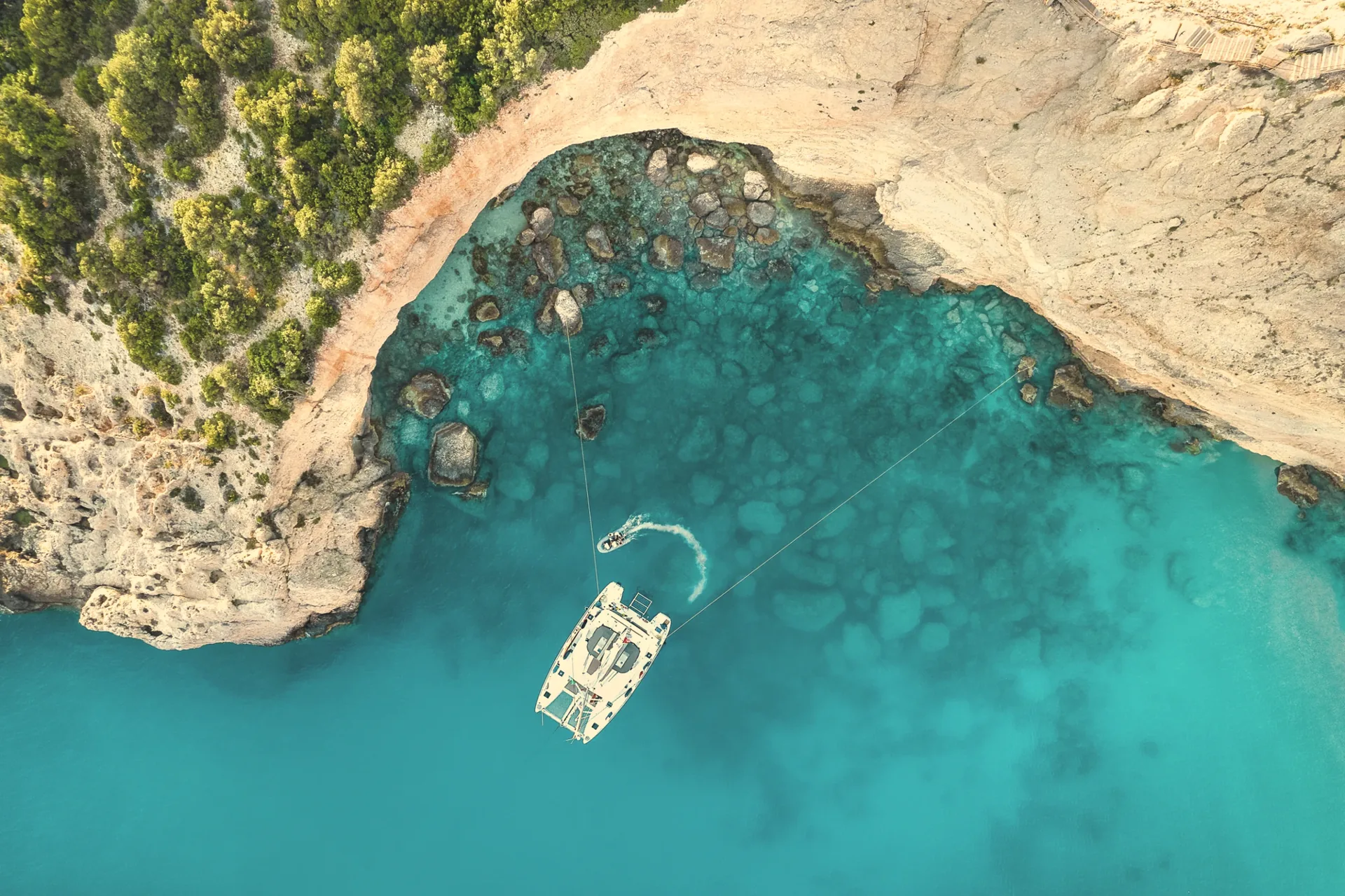 Aerial view of a catamaran in turquoise water in Greece