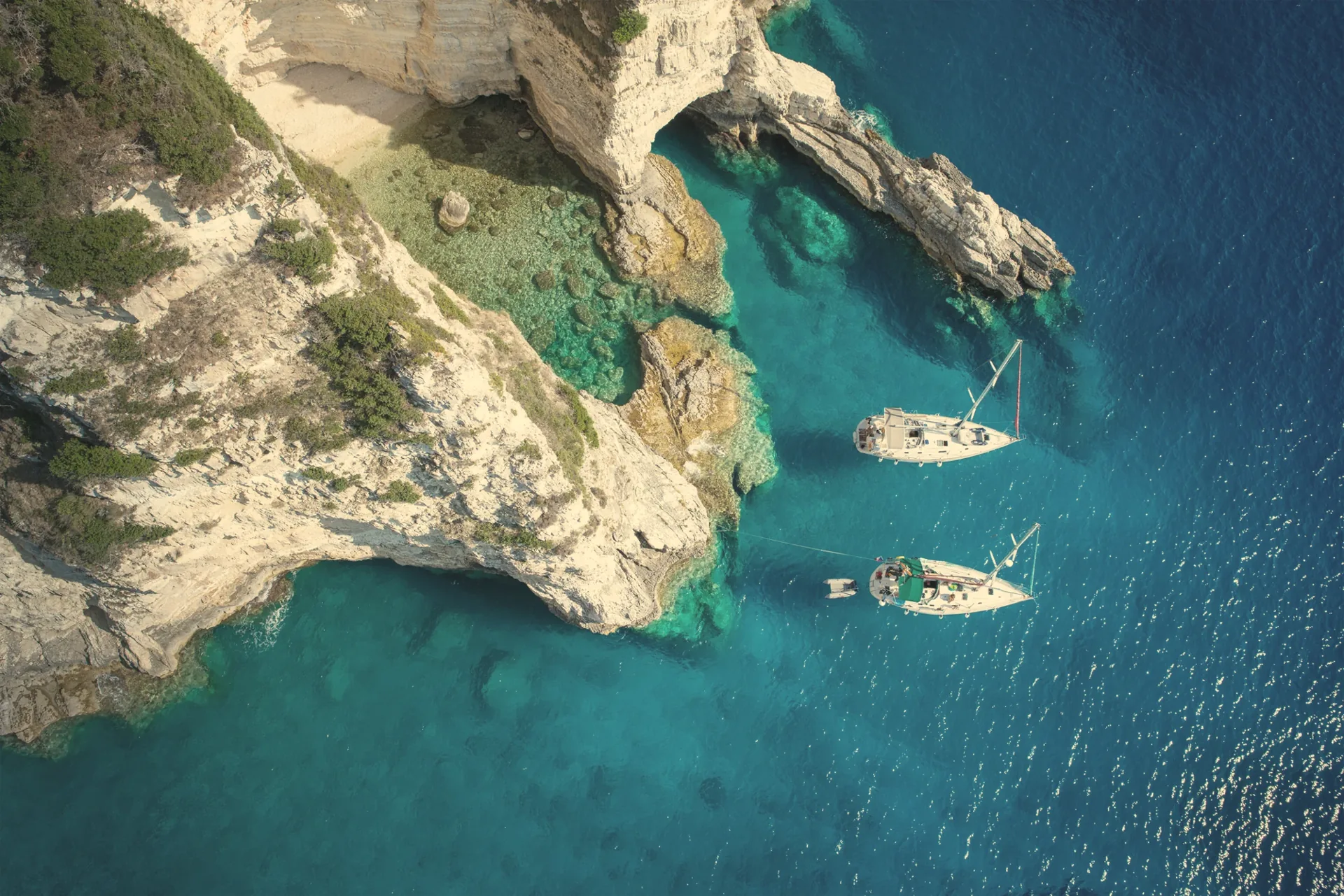 Sailboats by the sea caves of Paxos