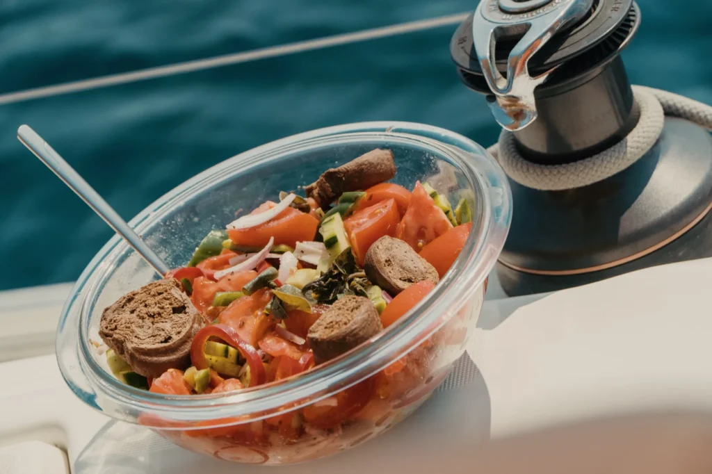 Greek salad with bread on the deck of a sailing yacht