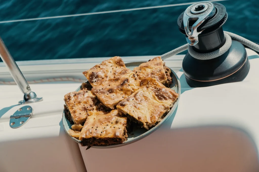 Plate of Greek pies on the deck of a sailing yacht