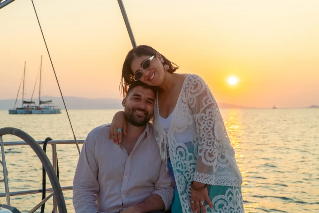 Friends together on the deck of a sailing yacht at sunset
