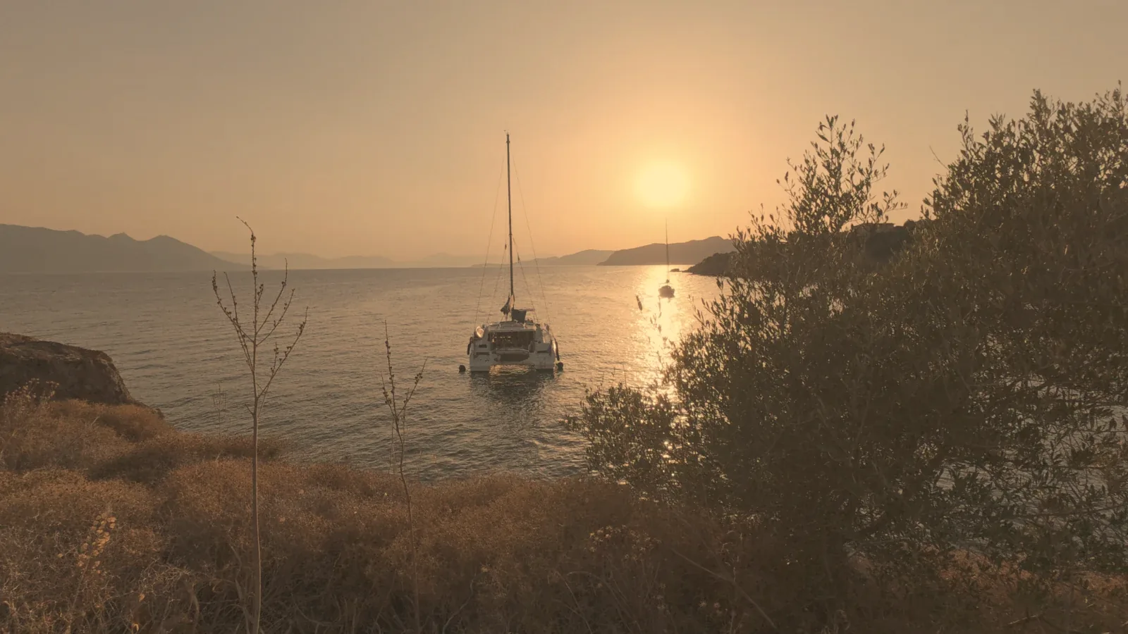 Sailing yacht at anchor at sunset in a quiet Saronic bay