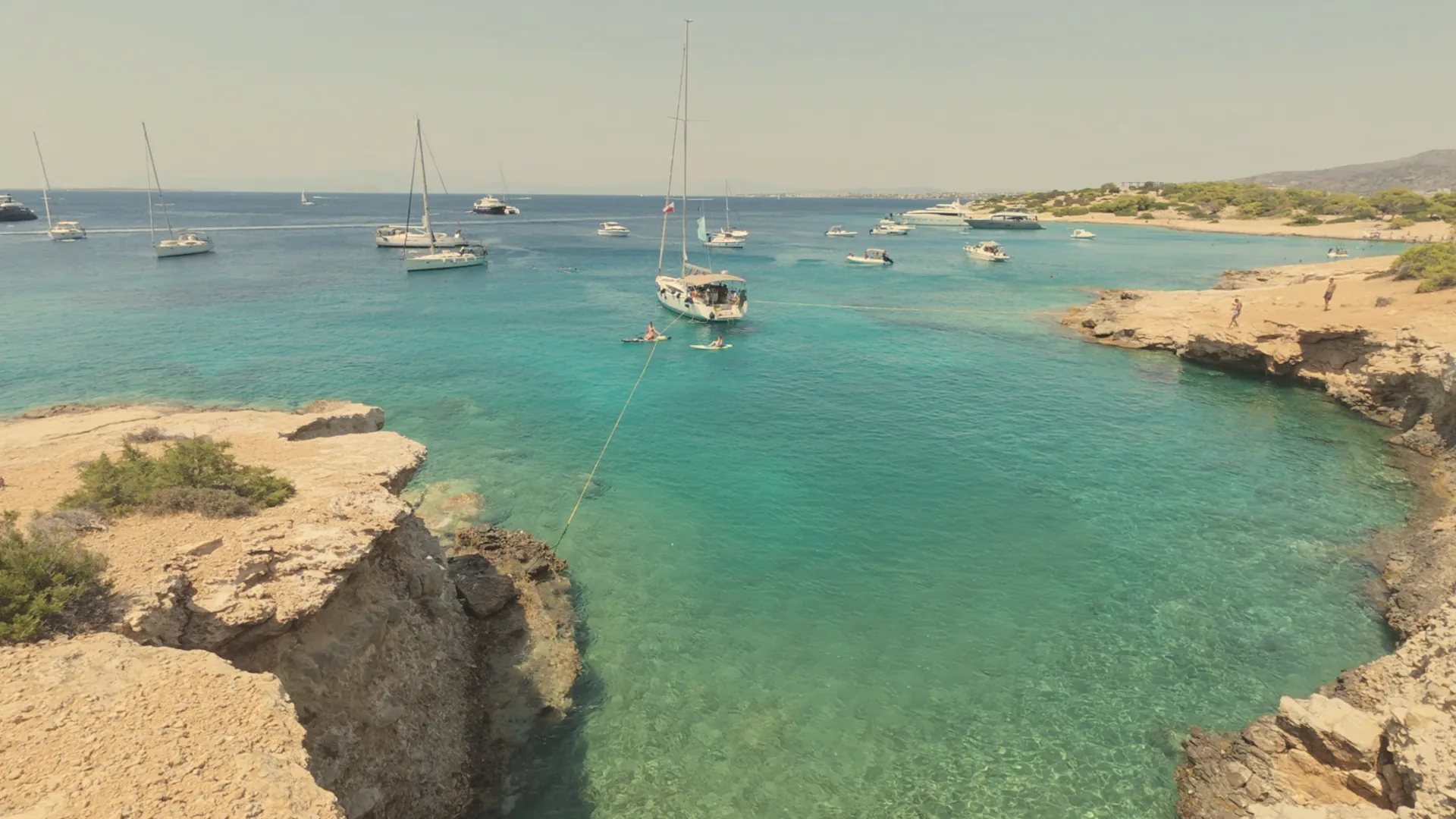 Yachts anchored in a turquoise bay in the Saronic Gulf